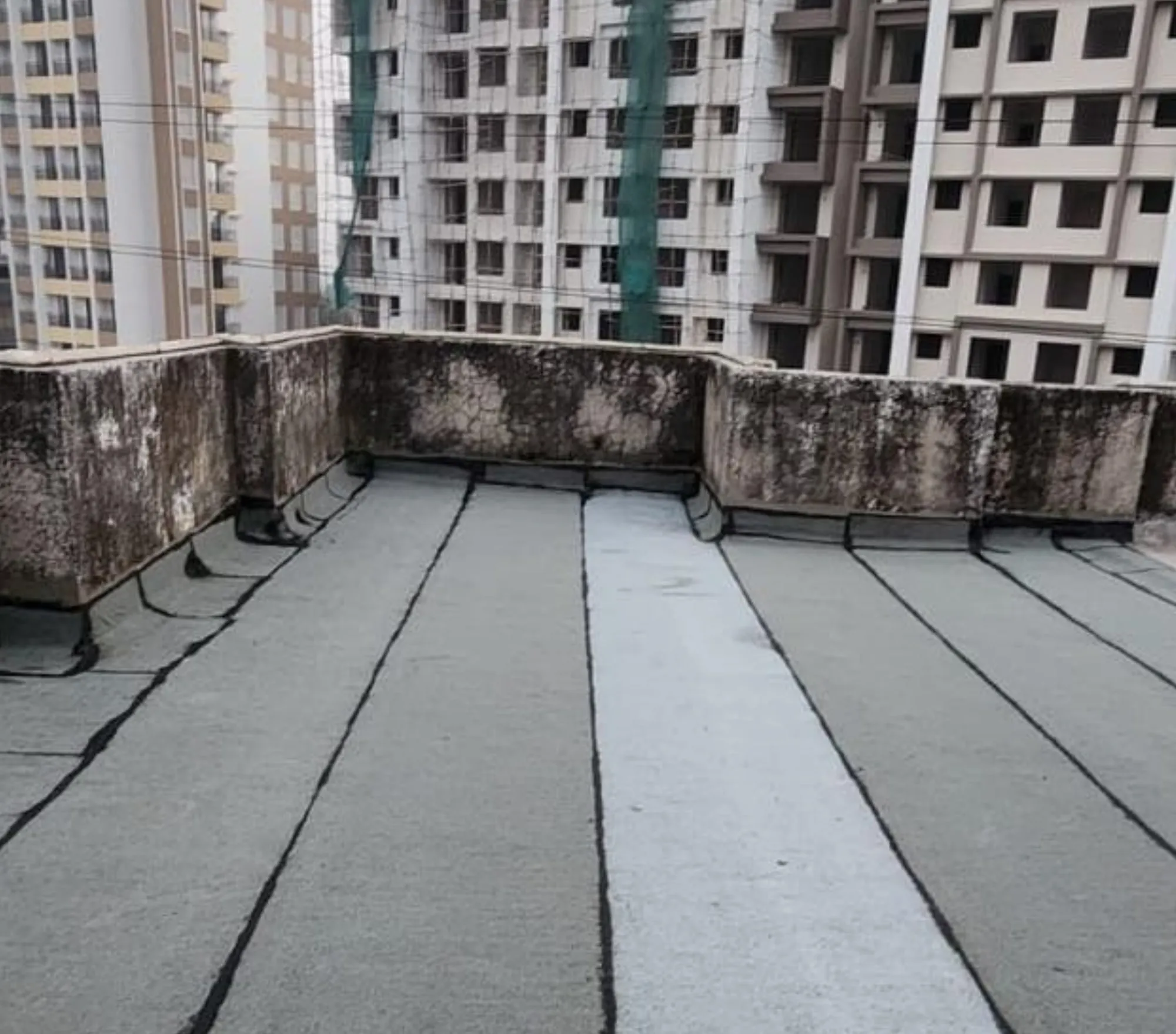 Mineral-finish membrane laid across a terrace — Mahadev Waterproofing